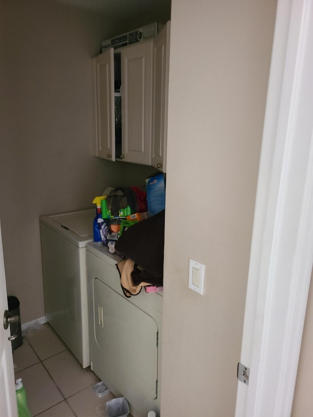 laundry room with cabinets, separate washer and dryer, and light tile patterned floors