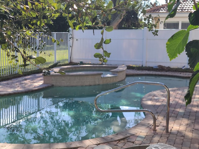 view of swimming pool featuring an in ground hot tub