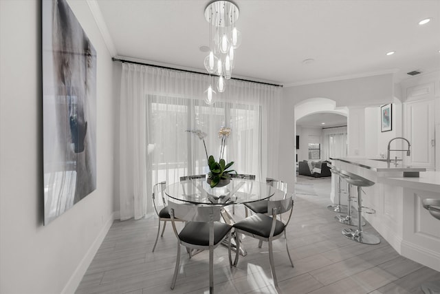 dining room with a healthy amount of sunlight, sink, and crown molding