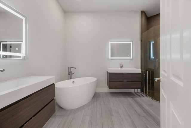 bathroom with hardwood / wood-style floors, vanity, and independent shower and bath