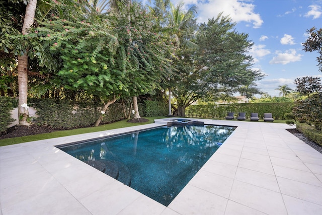 view of pool with an in ground hot tub and a patio