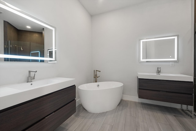 bathroom with wood-type flooring, vanity, and independent shower and bath