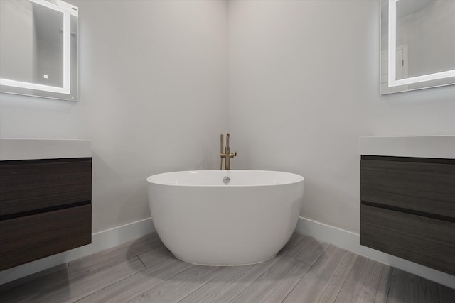 bathroom featuring a bath, vanity, and hardwood / wood-style flooring