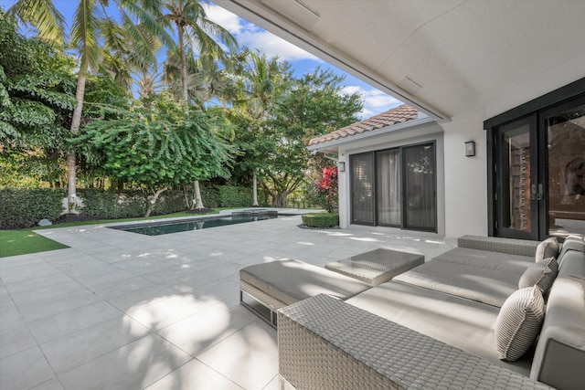 view of patio featuring an outdoor living space and a swimming pool with hot tub