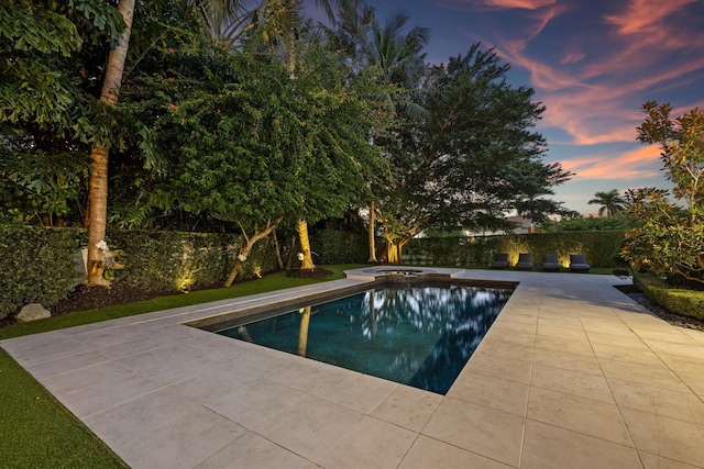 pool at dusk with a patio