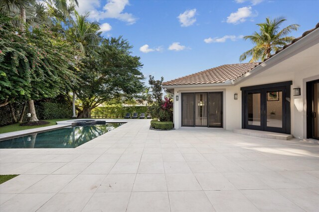 view of swimming pool featuring a patio area and french doors