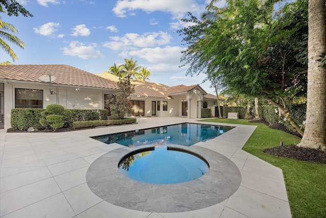 view of pool featuring a yard, an in ground hot tub, and a patio