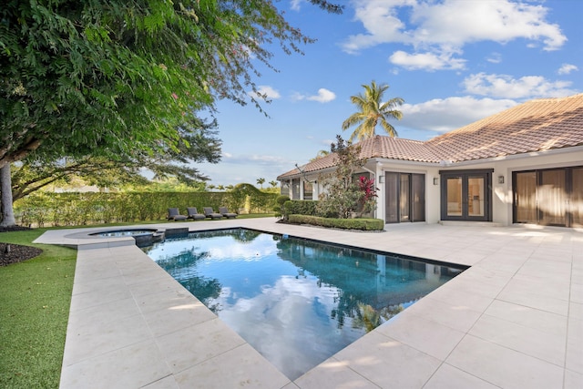 view of swimming pool featuring a patio area, an in ground hot tub, and french doors