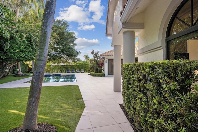 view of swimming pool with a yard and a patio