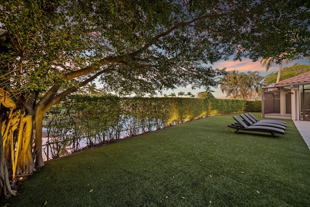 yard at dusk featuring a water view