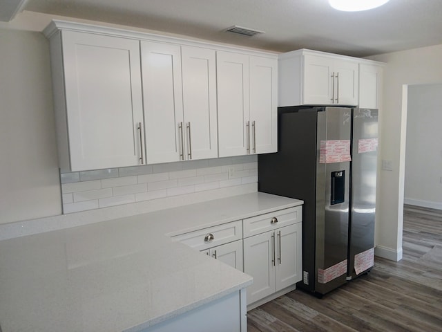 kitchen featuring white cabinets, stainless steel fridge, dark hardwood / wood-style floors, and tasteful backsplash