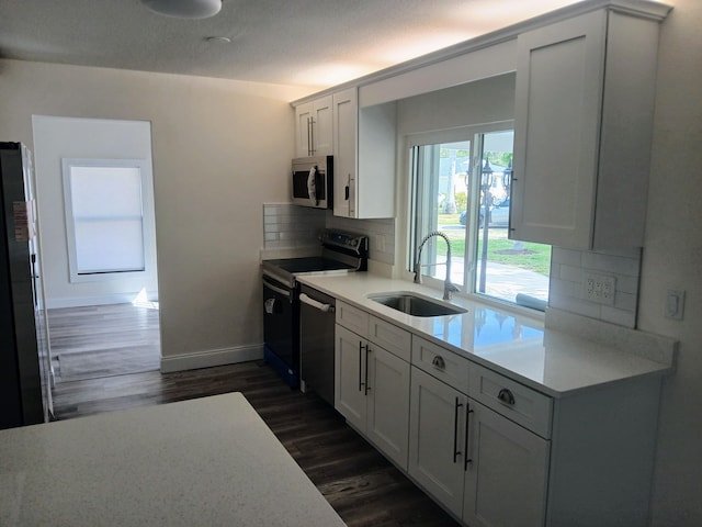 kitchen with tasteful backsplash, white cabinetry, sink, and appliances with stainless steel finishes