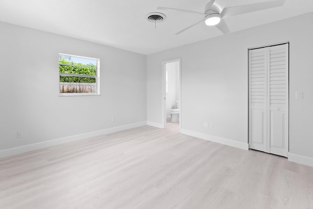 unfurnished bedroom with connected bathroom, ceiling fan, a closet, and light wood-type flooring