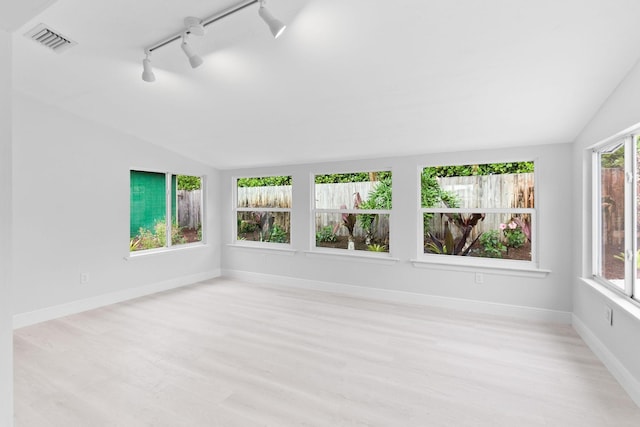 unfurnished sunroom with lofted ceiling and rail lighting