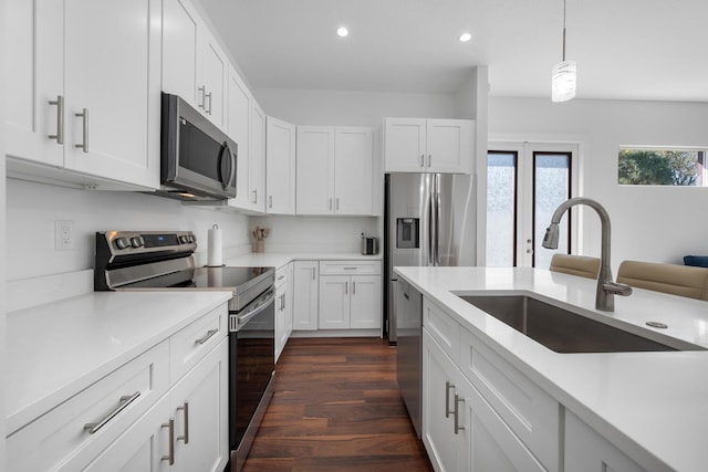 kitchen with white cabinetry, sink, stainless steel appliances, and hanging light fixtures