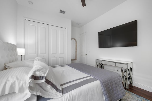 bedroom featuring ceiling fan, dark hardwood / wood-style floors, and a closet