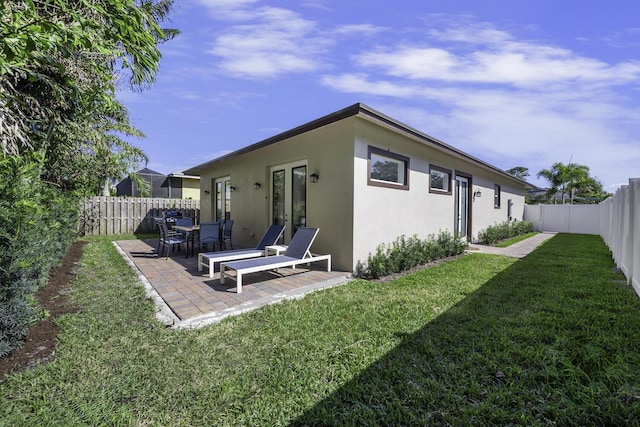 back of property featuring a yard, a patio area, and french doors