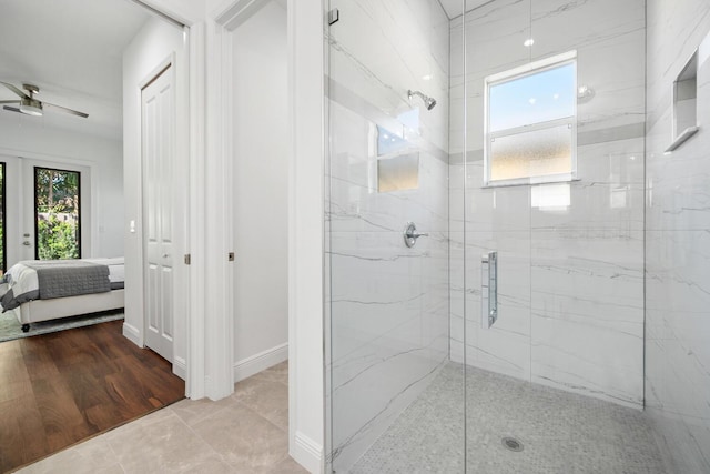 bathroom with an enclosed shower and ceiling fan