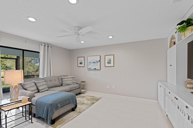 living room featuring ceiling fan and a textured ceiling