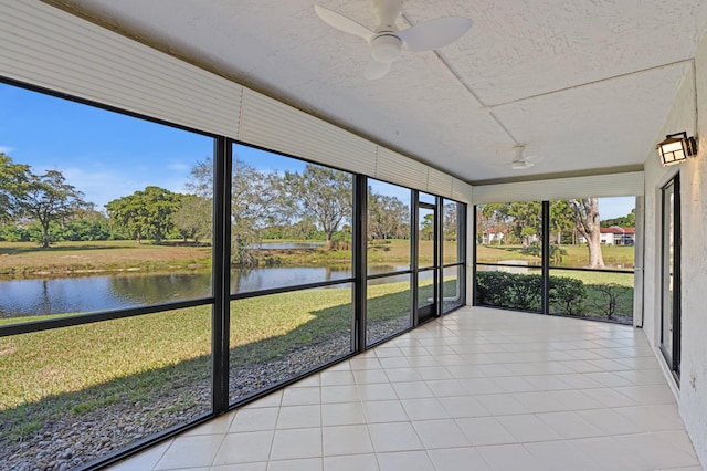 unfurnished sunroom featuring ceiling fan and a water view