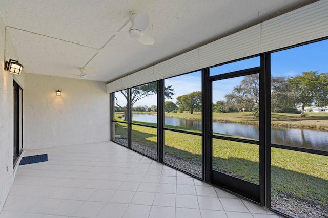 unfurnished sunroom featuring a water view and ceiling fan