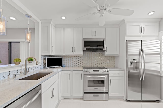 kitchen featuring sink, stainless steel appliances, hanging light fixtures, and white cabinets