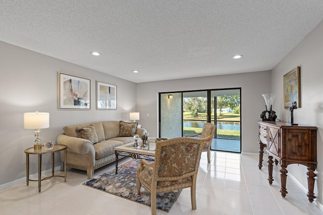 living room with a textured ceiling and light tile patterned floors