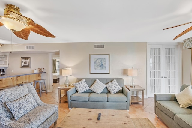 living room featuring ceiling fan, light tile patterned floors, and french doors