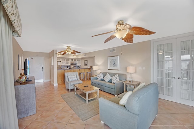 living room featuring ceiling fan, french doors, and light tile patterned flooring