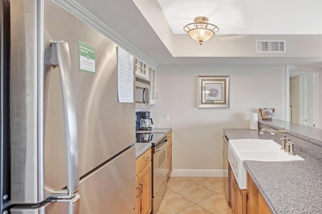 kitchen featuring light tile patterned floors, appliances with stainless steel finishes, and sink