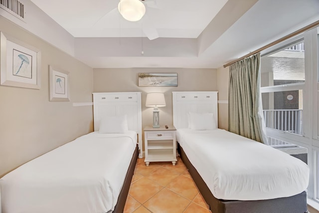 tiled bedroom featuring a tray ceiling