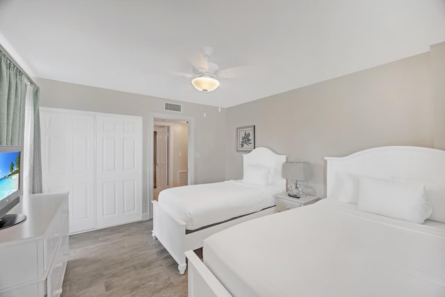 bedroom with ceiling fan, a closet, and light wood-type flooring