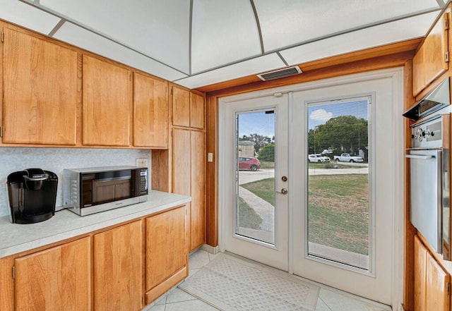 kitchen featuring french doors, wall oven, and light tile patterned floors