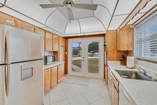 kitchen with french doors, sink, ceiling fan, light tile patterned flooring, and stainless steel appliances