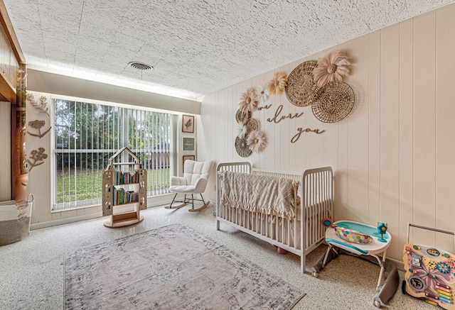 bedroom with wood walls and a nursery area