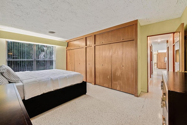 bedroom with a textured ceiling and a closet