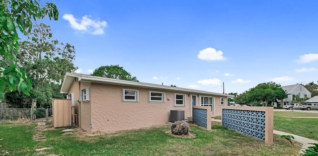 view of front facade featuring a front lawn and central AC unit