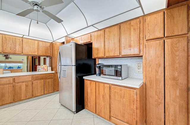 kitchen featuring decorative backsplash, stainless steel fridge, ceiling fan, and light tile patterned floors