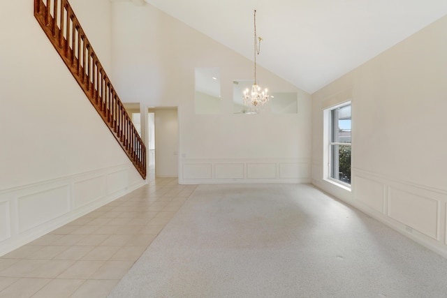 tiled dining area with lofted ceiling and an inviting chandelier