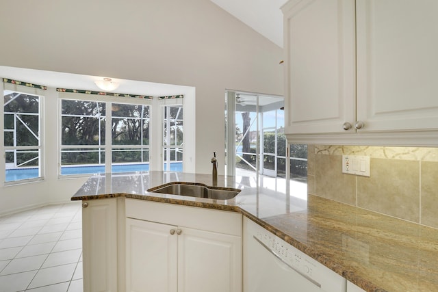 kitchen with white cabinetry, sink, dark stone countertops, and dishwasher