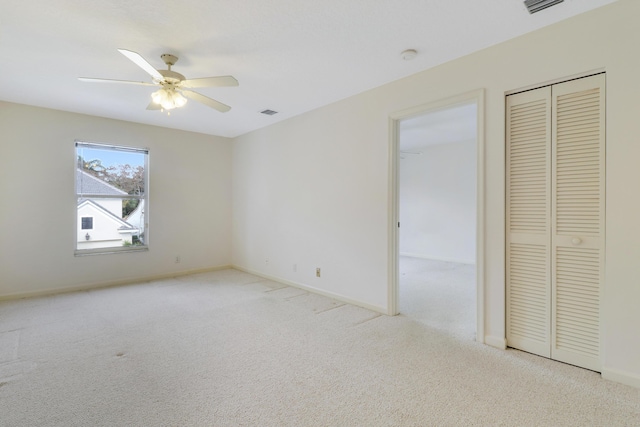 unfurnished bedroom with light colored carpet and ceiling fan