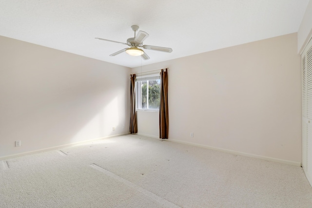 carpeted spare room featuring ceiling fan