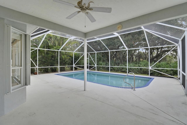 view of swimming pool featuring ceiling fan, a patio, and glass enclosure