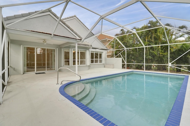 view of pool with a patio area, ceiling fan, and glass enclosure