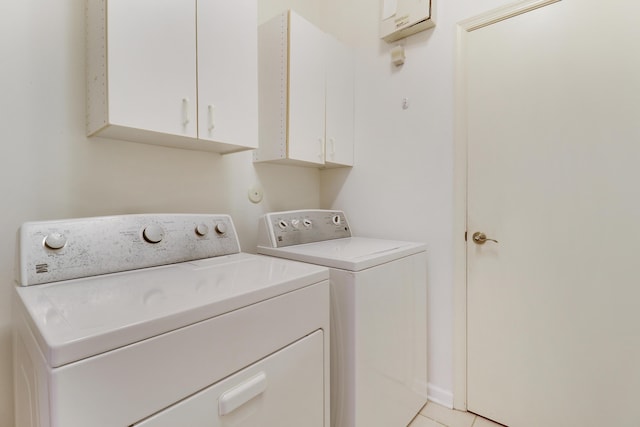 laundry area featuring cabinets, light tile patterned floors, and independent washer and dryer