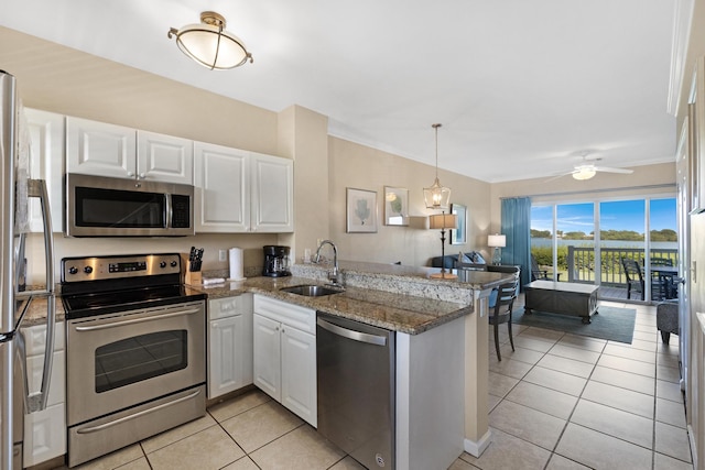 kitchen with kitchen peninsula, stainless steel appliances, white cabinets, and sink