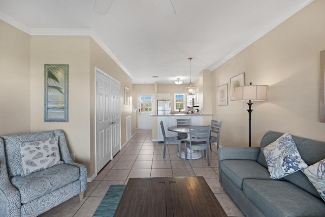 tiled living room featuring ornamental molding and an inviting chandelier