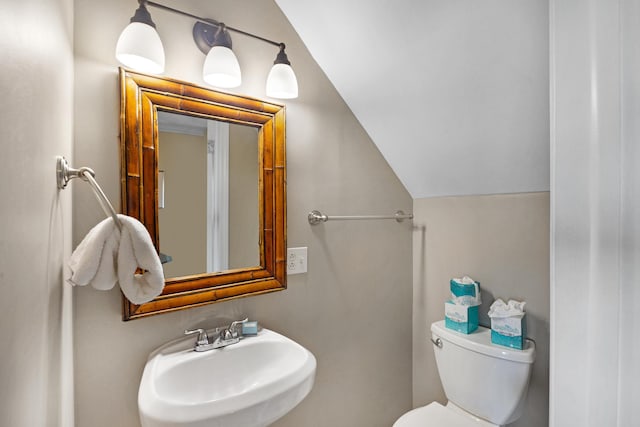 bathroom with sink, lofted ceiling, and toilet