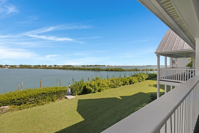 view of yard with ceiling fan and a water view