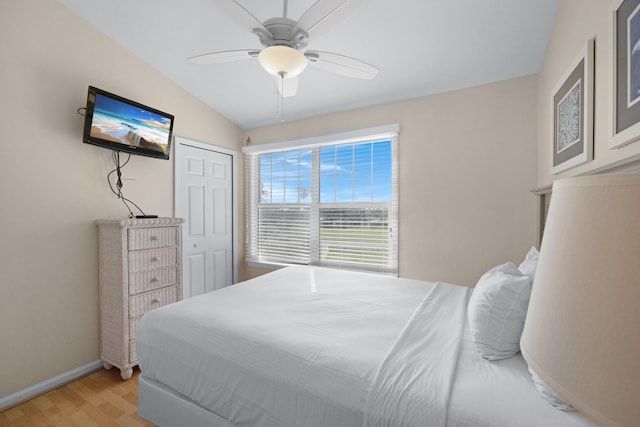 bedroom with lofted ceiling, a closet, ceiling fan, and light hardwood / wood-style floors